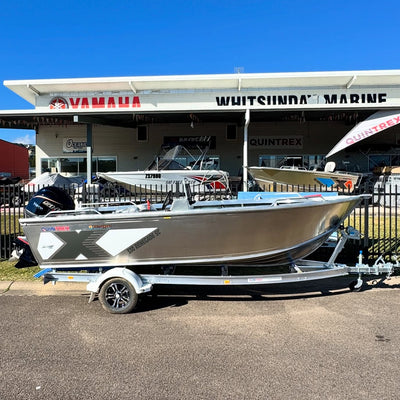 Boat on a trailer in front of a Yamaha and Whitsunday Marine building.